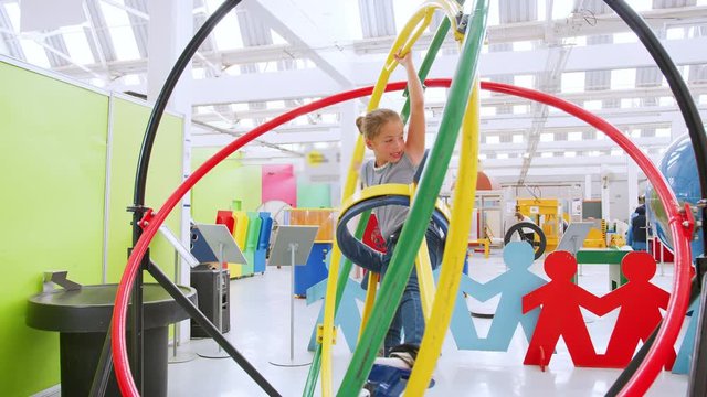 Young girl having fun on human gyroscope at a science centre