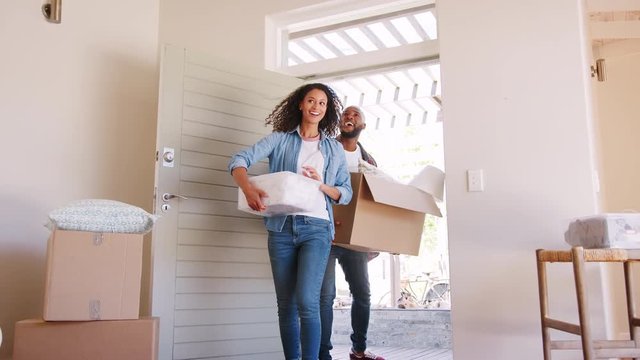Slow Motion Shot Of Couple Carrying Boxes Into New Home On Moving Day