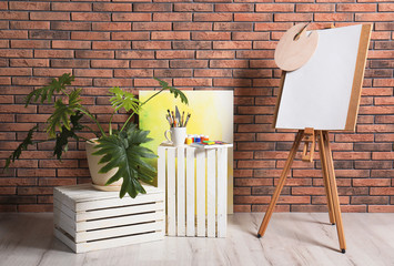 Artist's workshop interior with easel and set of professional equipment. Space for design