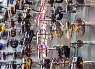 Fototapeta na wymiar Sunglasses on the stand at the counter. Sunglasses for sale.