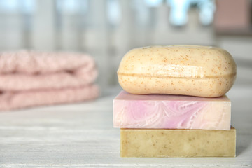 Stack of different soap bars on table. Space for text