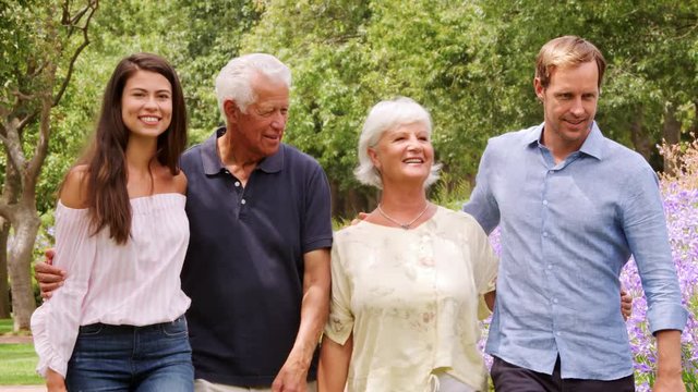 Young adult couple and parents walking in a park, close up