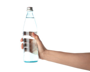 Woman holding glass bottle with water on white background