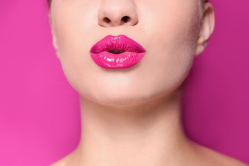 Beautiful young woman with perfect lips makeup on color background, closeup