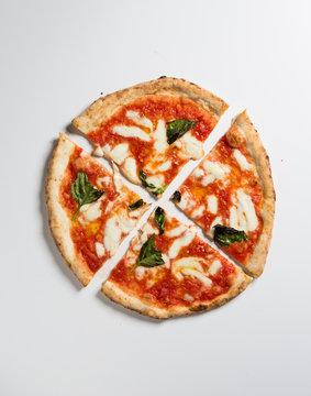 Cut pizza over white surface.
