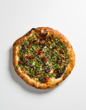 Whole pizza over white surface.