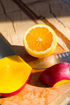 Orange and mango on cutting board