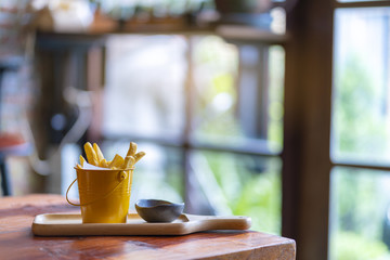 French fries and ketchup on wood board background.