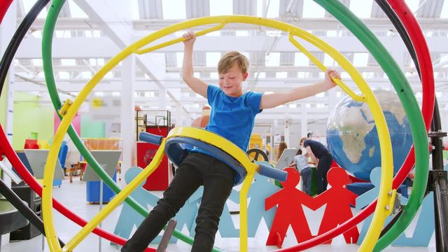 Young boy having fun on human gyroscope at a science centre