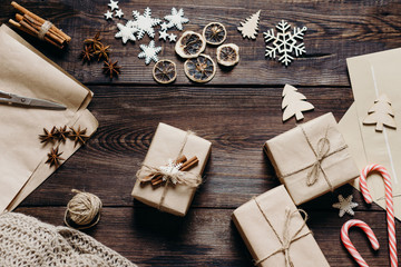 Christmas and New Year preparation. Gift boxes in craft paper and festive decorations, close up. DIY and creativity, winter holidays, family celebration, home weekend concept