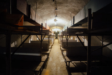 Wooden double-decker beds inside old abandoned soviet bomb shelter 