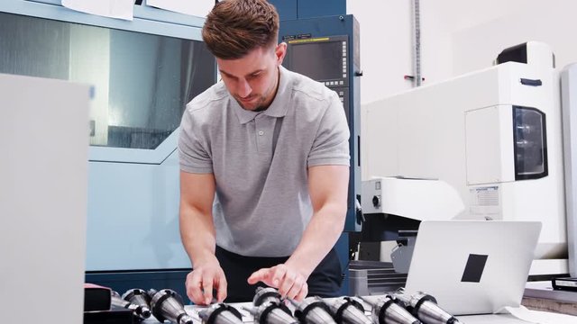 Male Engineer Measuring CAD Drawings In Factory