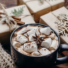 Christmas and New Year traditions. Gift boxes, hot chocolate and knitted blanket, close up. Winter holidays celebration concept