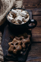 Christmas and New Year cozy holiday composition with hot chocolate, gingerbread cookies and knitted blanket. Winter holidays celebration concept