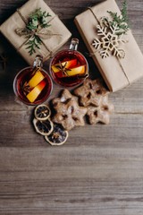 Christmas poster template, composition with gift boxes, mulled wine and gingerbread cookies on rustic background. Creative greeting card. Winter holidays celebration concept