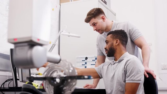 Two Male Engineers Uses CMM Coordinate Measuring Machine In Factory