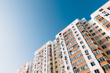 Fototapeta premium multi-colored multi-storey high-rise residential building against the blue sky