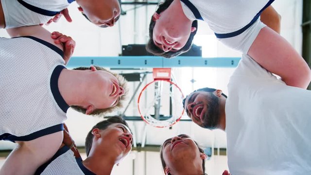 Low Angle View Of Male High School Basketball Players Having Team Talk With Coach
