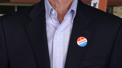 Senior caucasian man in formal clothing with Voted sticker