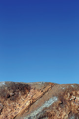Close up image of boulder against blue sky