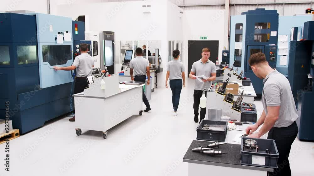 Wall mural busy engineering workshop with workers using cnc machinery