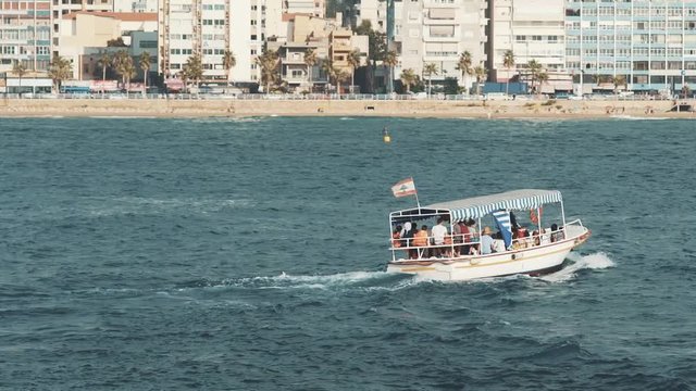 Little ship carrying with people from a little coast and then crossing the sea.