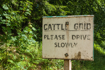 Holm of Drumlanrig, Scotland, UK - June 18, 2012: Closeup of black on white old cattle grid sign along the road.