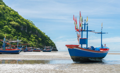 Fototapeta premium Blue Fishing Boat on Sea Sand with Green Mountain at Khao Kalok Beach Thailand Right Frame