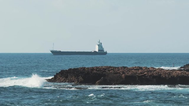 Sea and coastal waves scene near the city of Beirut with a small island in the middle.