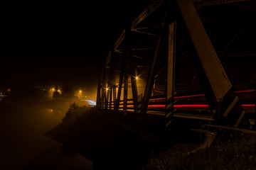 Fog creeps through a truss bridge at night in Long Lake NY, ADK Mountains