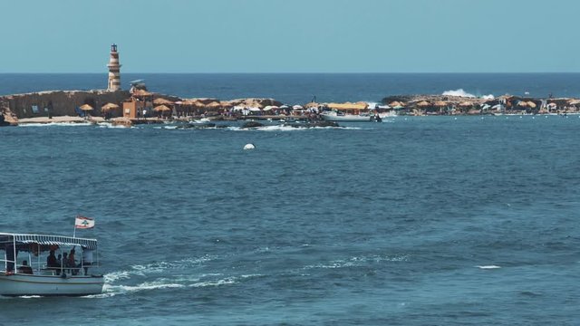Little ship carrying with people and then crossing the sea. As it can be seen an island in the distance.