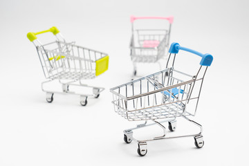 Close up of supermarket grocery push cart for shopping with black wheels on white background. Concept of shopping.
