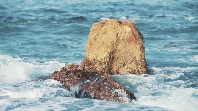 Rock among a wavering waves near the island.