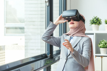 confident Muslim office worker wearing VR technology glasses