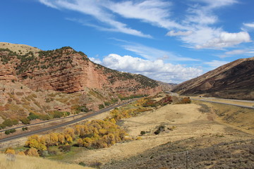 Echo Canyon , Utah . Beautiful canyon that the highway and the railroad uses to pass the rugged landscape of this region. wonderful blue sky with a few clouds and colorful bushes and shrubs