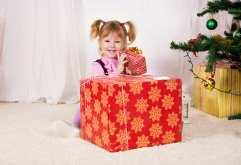 little girl with Christmas gifts near the Christmas tree