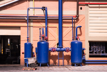 Blue air compressed tanks outside factory. Industrial equipment - obrazy, fototapety, plakaty