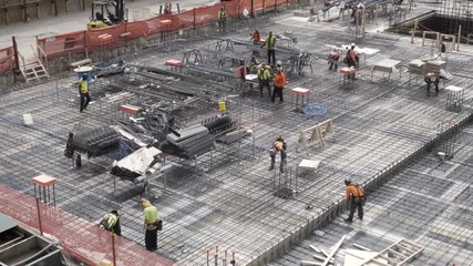 Workers on a construction site bulding foundations of a new building