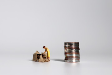 A pile of coins and miniature people. A concept of income distribution.