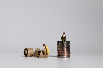A pile of coins and miniature people. A concept of profit and poverty.