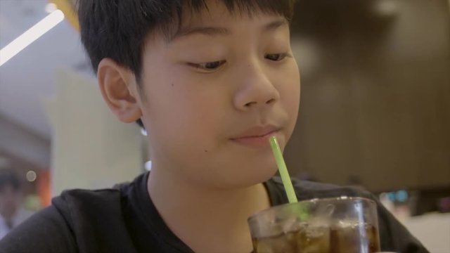 Slow motion of Teenager drinking a glass of refreshing cold fizzy cola drink with smile face.