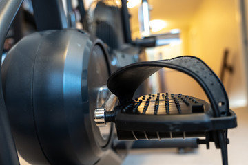 Stationary exercise bike pedals in home gymnasium to keep fit and healthy