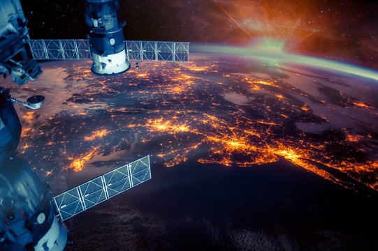 Atlantic coast of the United States night lights and sunrise with lens flare from the space station. Earth with eclipse on starry sky. Elements of this image furnished by NASA.