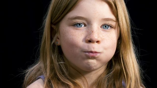 Young girl being silly and puffing our her cheeks