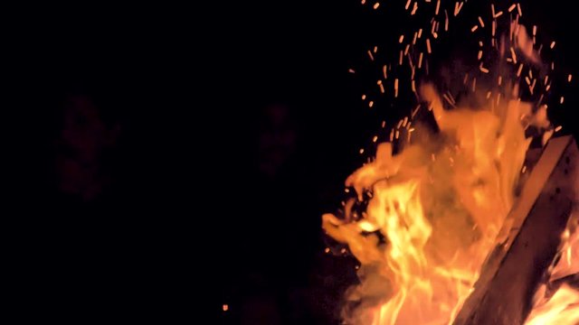 Slow motion view of buring embers coming from a beach campfire. Close up view of flames.