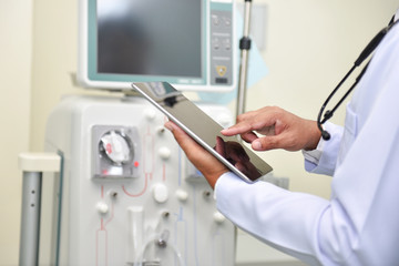 Young doctors use digital tablet with dialysis equipment in Asian hospitals.