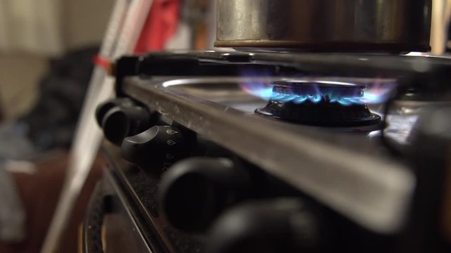 Man sets tea pot onto stainless stove top
