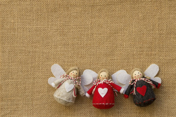3 Weihnachtsengel mit Herzen aus Filz auf Hintergrund aus Jute traditionell
