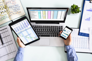 Businesswoman Using Various Applications On Electronic Devices