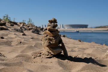 Pyramid of stones on the river bank. The hierarchy of power. Career growth.